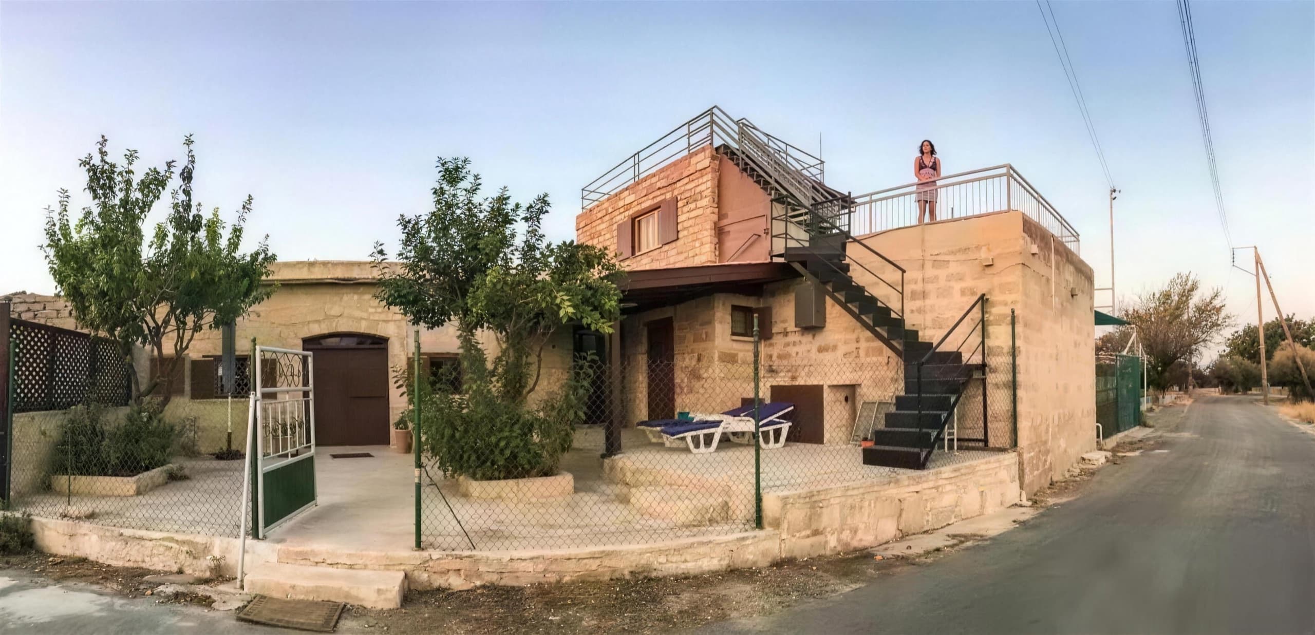 Η πέτρινη πρόσοψη του σπιτιού με τη σκάλα προς τη ταράτσα